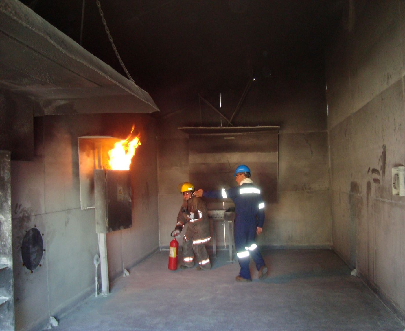 Instructor de Cap Reitter guiando a un participante en una práctica de extinción de fuego con extintor